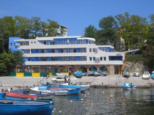 a large white building with boats in the water at Ribarska Sreshta Family Hotel in Tsarevo