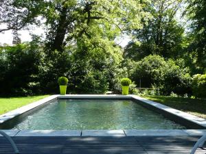 un charco de agua con dos macetas. en Maison d'hôtes "Les Jardins de Mazamet", en Mazamet