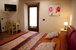 a bedroom with a bed and a desk and a television at Thalassa Locanda B&B e appartamento in Arcidosso