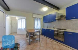 una cocina con armarios azules y una mesa. en Casamarin8, en Caorle