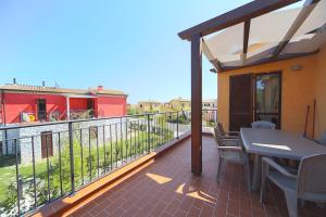 eine Terrasse mit einem Tisch und Stühlen auf dem Balkon in der Unterkunft Adamo ed Eva Resort in Numana