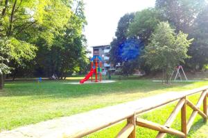 einen Park mit einem Spielplatz mit einer roten Rutsche in der Unterkunft Livada in Gorizia