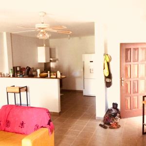 a living room with a couch and a kitchen at L'Eskale Guyane in Montjoly