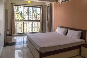 una cama en una habitación con una ventana grande en Comfy 2BHK Pool facing Full Aircon Apt in Candolim, en Candolim 13 fotos más