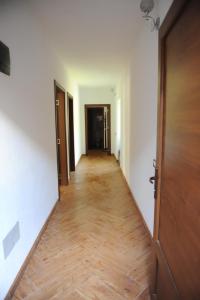 an empty hallway with a wooden floor and a door at Guesthouse Demushi in Valbonë