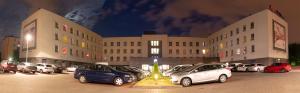 a parking lot with cars parked in front of a building at Focus Hotel Katowice Chorzów in Chorzów