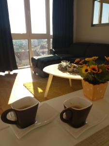 Sala de estar con 2 tazas de café y mesa en Anja, en Bijeljina