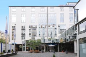 a white building with a walkway in front of it at Maritim Hotel München in Munich