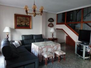 un soggiorno con divano e una scala di Casa Turistica Termas aparcamiento y desayuno incluido a Mérida