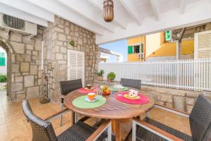 a patio with a wooden table and chairs at Xarus 1 in Alcudia