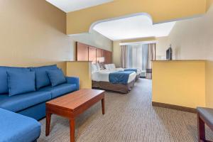 une chambre d'hôtel avec un canapé et un lit dans l'établissement Comfort Suites, à Findlay