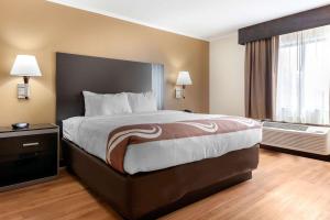 a hotel room with a large bed and a window at Quality Inn in Fairborn +22 photos