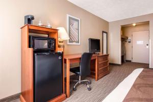 a hotel room with a computer and a desk with a microwave at Quality Inn & Suites New Castle in New Castle +28 photos