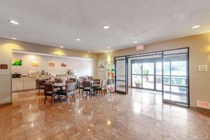 a restaurant with a table and chairs in a room at Quality Suites in Austin