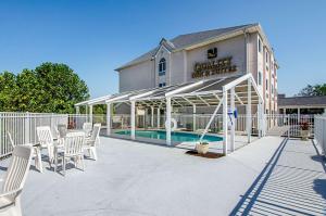 um pátio com cadeiras brancas e uma piscina em Quality Inn & Suites I-81 Exit 7 em Bristol