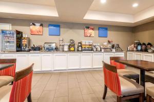 a restaurant with a counter and tables and chairs at Comfort Inn Lathrop Stockton Airport in Lathrop