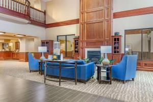 a living room with blue chairs and a fireplace at Comfort Suites in Findlay
