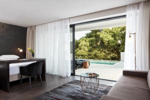 a bedroom with a bed and a desk and a sliding glass door at Azur Hotel in Athens