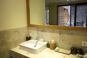 a bathroom with a white sink and a mirror at Sapodilla Ubud in Ubud