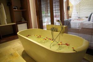 a bathroom with a tub with flowers on it at Sapodilla Ubud in Ubud