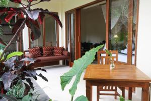 a living room with a table and a plant at Sapodilla Ubud in Ubud