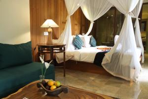 a bedroom with a bed and a bowl of fruit on a table at Sapodilla Ubud in Ubud