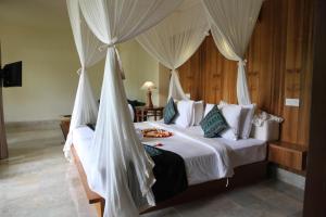 a bedroom with a bed with a canopy at Sapodilla Ubud in Ubud