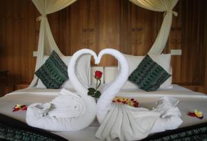 two swans making a heart on a bed at Sapodilla Ubud in Ubud