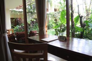 a table and chairs with a table and a window at Sapodilla Ubud in Ubud