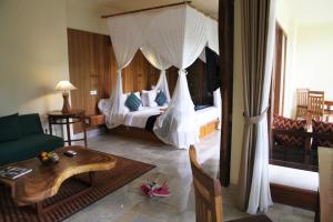 a bedroom with a bed with a canopy at Sapodilla Ubud in Ubud