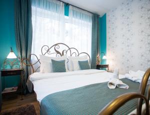 a bedroom with a bed and a window with blue walls at Garni Hotel DUM in Belgrade