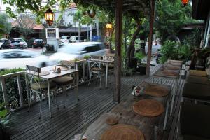 a wooden deck with tables and chairs on a street at Sapodilla Ubud in Ubud