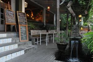 a restaurant with a table and chairs and a fountain at Sapodilla Ubud in Ubud