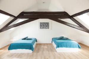 2 Betten in einem Zimmer mit weißen Wänden und Holzböden in der Unterkunft Boardinghouse s' Johanner in Saarbrücken