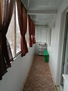 トリヤッチにあるКвартираの窓2つと緑のベンチのある狭い廊下