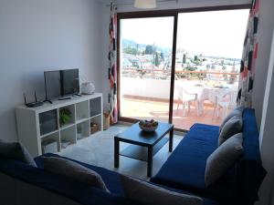 a living room with a blue couch and a table at Panorama de Nerja in Nerja