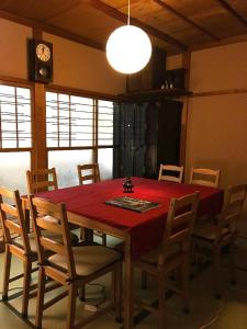 uma sala de jantar com uma mesa vermelha e cadeiras em Fuji House em Takayama