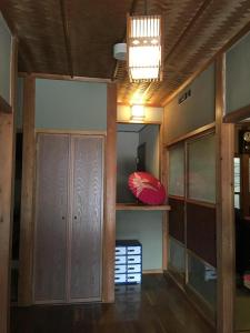 Habitación con armario y sombrilla roja en un estante. en Fuji House en Takayama