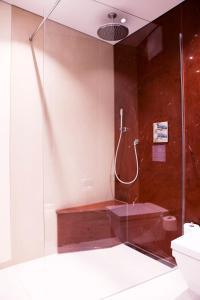 uma casa de banho com uma cabina de duche em vidro e um WC. em Schwitzer's Hotel am Park em Waldbronn