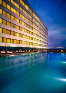 a building with a swimming pool in front of it at Vivanta Coimbatore in Coimbatore