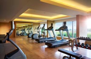 een fitnessruimte met loopbanden en crosstrainers in een kamer bij Vivanta Coimbatore in Coimbatore