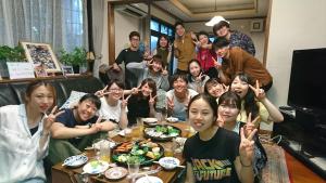 Un groupe de personnes assises autour d'une table et mangeant de la nourriture dans l'établissement Full house Miyajima, à Miyajima