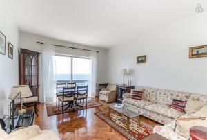 uma sala de estar com um sofá e uma mesa em Apartamento Com Vista Para O Mar no Porto