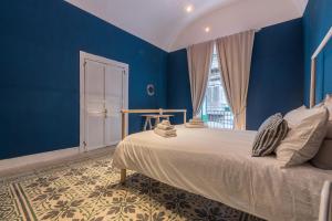 una camera blu con un letto e una finestra di Qasr Home Beautiful apartment in Palermo a Palermo
