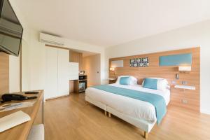 a hotel room with a large bed and a television at Hôtel Hélios in Juan-les-Pins