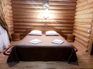 a bedroom with a bed in a log cabin at Mustang Guest House in Izhevsk