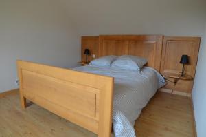 a bedroom with a bed with a wooden headboard at Gîte Cigogne in Odratzheim