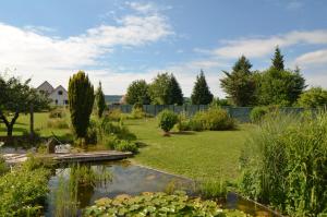 a garden with a pond and a fence at Gîte Cigogne in Odratzheim