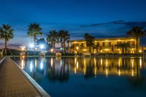 a building with palm trees and a swimming pool at night at Club Residence La Castellana Mare in Belvedere Marittimo