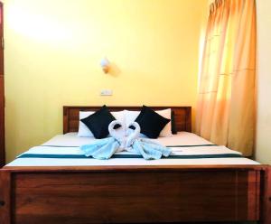 a bedroom with a bed with towels on it at Randhila Beach View Hotel in Hikkaduwa